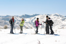 Group snowshoeing looking over the snowy mountains of Park City Utah